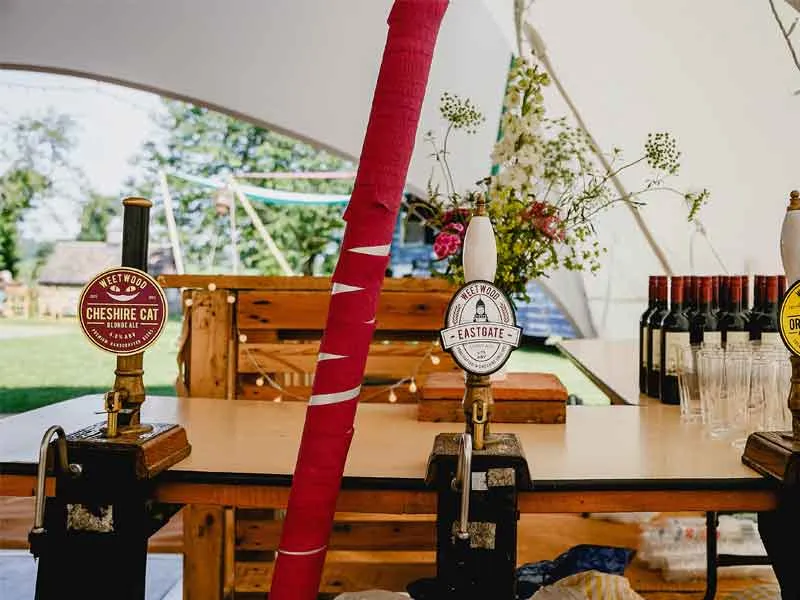 Beer pumps on a bar inside a marquee