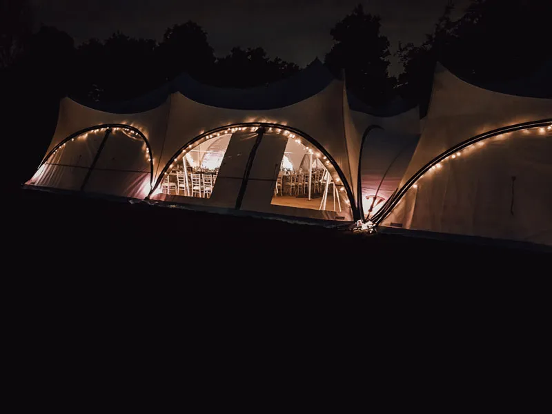 Festoon lighting picking out the edge of a Milestone structure after dark